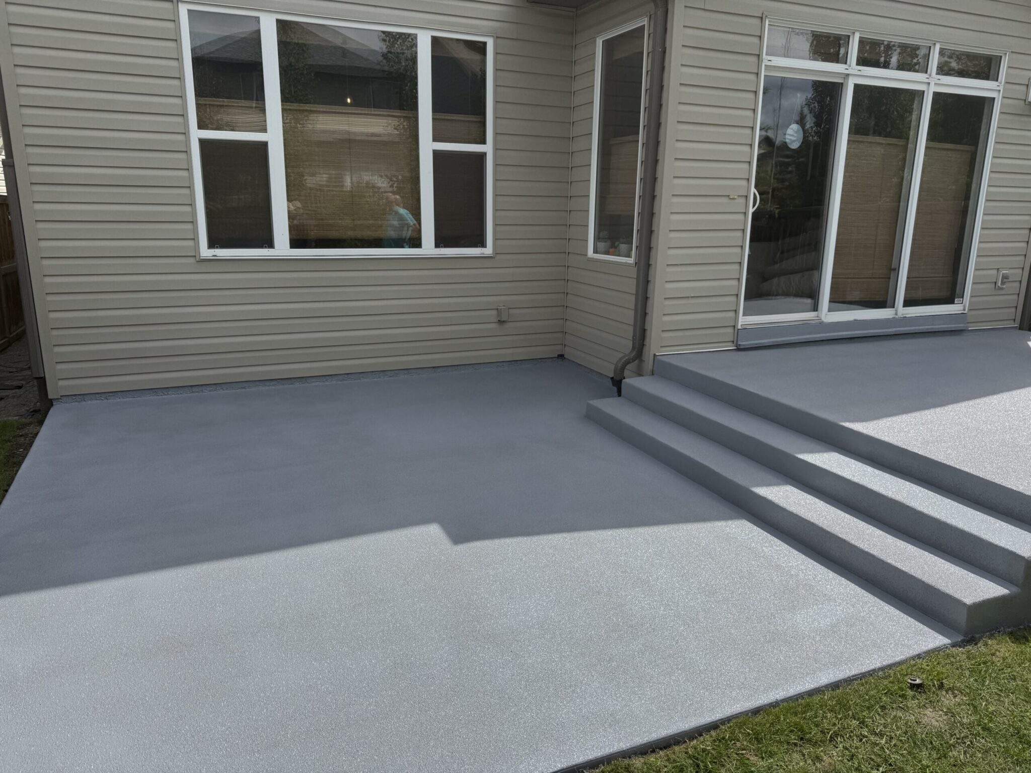 Seamless outdoor polyaspartic flake coating installed on a concrete patio deck on Vancouver Island.