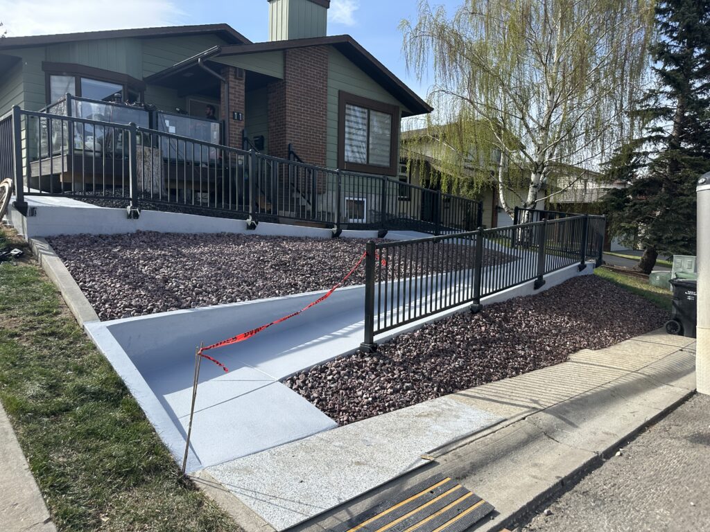 High-traction non-slip polyaspartic flake coating installed on an outdoor residential concrete walkway on Vancouver Island.