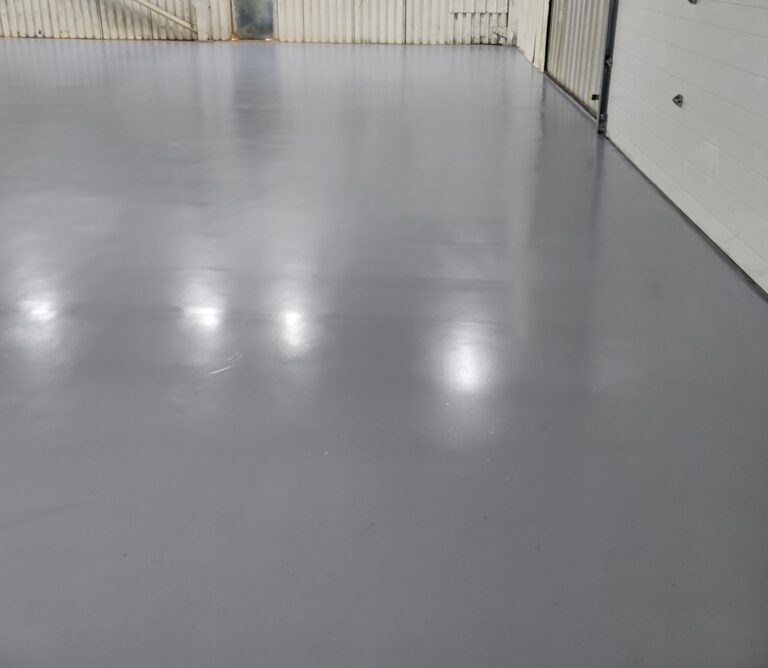 Heavy-duty grey polyaspartic commercial warehouse epoxy flooring installation on Vancouver Island.
