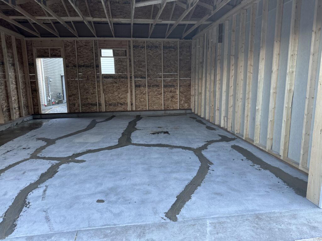 Residential garage concrete floor undergoing crack repair and dust-controlled diamond grinding on Vancouver Island.
