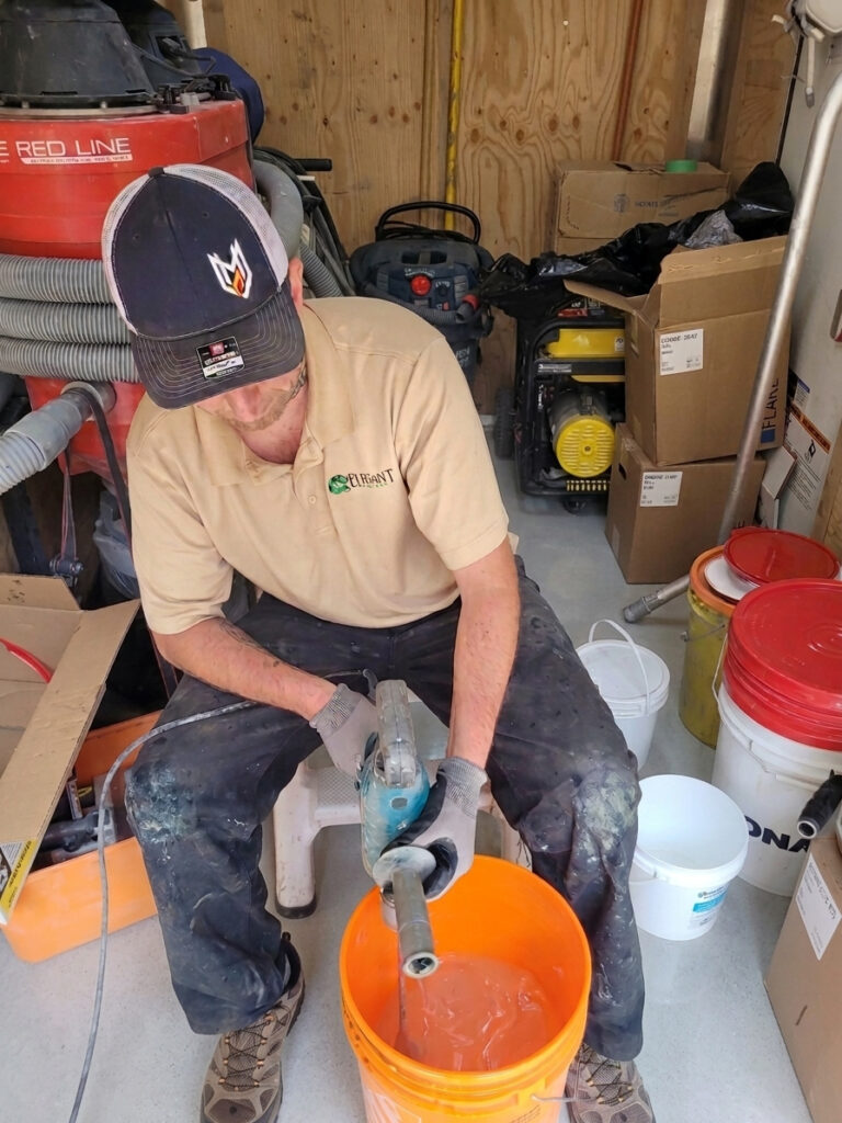 installer mixing high performance polyaspartic resin for garage floor coating on vancouver island